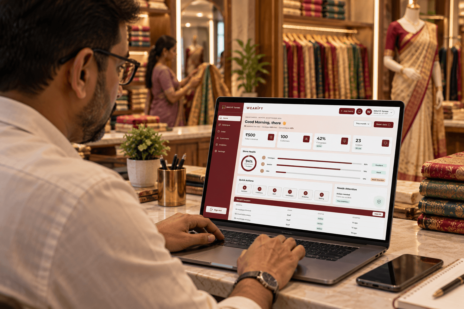 A store owner reviewing the Wearify Store Dashboard on a laptop in a saree store